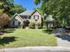 Charming brick home featuring a well-manicured lawn, mature trees, and classic architectural details at 130 Delaney Cir, Summerville, SC 29485