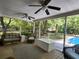Cozy screened-in porch with wicker furnishings, ceiling fans, and serene views of the backyard pool area at 130 Delaney Cir, Summerville, SC 29485