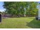 A home's backyard featuring a lush lawn, privacy fence, and shade trees at 1341 Belle Grove Cir, Hanahan, SC 29410