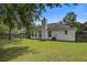 Expansive backyard featuring lush green lawn, mature tree, and a white home exterior with a brick chimney at 1341 Belle Grove Cir, Hanahan, SC 29410