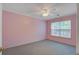 A naturally lit bedroom with pink walls, carpeted floor, and a ceiling fan at 1341 Belle Grove Cir, Hanahan, SC 29410