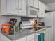 Bright kitchen features white cabinets, stove, microwave, and light gray countertops at 1341 Belle Grove Cir, Hanahan, SC 29410