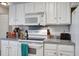 Bright kitchen features white cabinets, stove, microwave, and light gray countertops at 1341 Belle Grove Cir, Hanahan, SC 29410