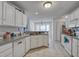 Bright kitchen with white cabinets, tile floor, and ample counter space at 1341 Belle Grove Cir, Hanahan, SC 29410