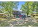 Large backyard featuring a screened porch, patio with seating, and mature trees at 14 Newark Ave, Goose Creek, SC 29445