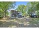 Large backyard boasting a screened porch, patio, and lush mature trees at 14 Newark Ave, Goose Creek, SC 29445