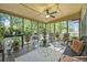 Inviting screened porch with ceiling fan, plants, and cozy seating area at 14 Newark Ave, Goose Creek, SC 29445