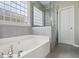 Bathroom boasting a separate shower and soaking tub, a glass block window, and modern gray tile at 1409 Endicot Way, Mount Pleasant, SC 29466
