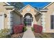 Elegant home entrance featuring a striking arched doorway and vibrant red bushes lining the walkway at 1409 Endicot Way, Mount Pleasant, SC 29466