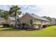 Side exterior view of a tan home with manicured shrubs, healthy green grass, and a tall palm tree at 1409 Endicot Way, Mount Pleasant, SC 29466