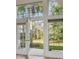 Bright living room featuring French doors leading to a backyard with mature trees, and transom windows at 1409 Endicot Way, Mount Pleasant, SC 29466