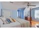 A lovely primary bedroom features beautiful light blue walls, a four-poster bed, and gleaming hardwood floors at 1417 Pine Island View, Mount Pleasant, SC 29464