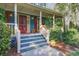 Close up of a cozy porch with wooden columns, steps and lush greenery at 1417 Pine Island View, Mount Pleasant, SC 29464