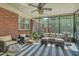 Inviting screened porch with brick wall, comfortable seating, and a striped rug at 1421 Fairfield Ave, Charleston, SC 29407
