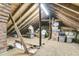 View of the unfinished attic with exposed wood beams, storage boxes and a brick chimney at 1450 E Montague Ave, North Charleston, SC 29405