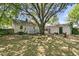 Spacious backyard features a large shade tree, patio area, wooden privacy fence, and detached garage at 1450 E Montague Ave, North Charleston, SC 29405