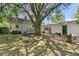 A lush and green backyard featuring a wooden deck area with seating and a large shade tree at 1450 E Montague Ave, North Charleston, SC 29405