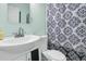 Well-lit bathroom with a white sink and toilet, featuring a black and white patterned shower curtain at 1450 E Montague Ave, North Charleston, SC 29405