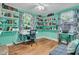 Bright bedroom with turquoise walls, built-in bookshelves, hardwood floors, and natural light from large windows at 1450 E Montague Ave, North Charleston, SC 29405