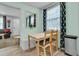 Bright dining area with a light-colored table set, decorative curtains, and view to the living room at 1450 E Montague Ave, North Charleston, SC 29405