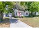 Well-maintained home with a detached garage, pink front door, manicured lawn, and a paved driveway at 1450 E Montague Ave, North Charleston, SC 29405