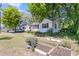 Charming home with a bright pink door and black shutters, complemented by green landscaping and a detached garage at 1450 E Montague Ave, North Charleston, SC 29405