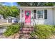 Charming home with a pink front door, brick steps, and nicely landscaped green shrubs at 1450 E Montague Ave, North Charleston, SC 29405