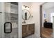 Modern bathroom with wood vanity, elegant round mirror, decorative tile floor, and bright lighting at 1526 Old Rivers Gate Rd, Mount Pleasant, SC 29466