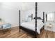 Bedroom featuring a chandelier, four poster bed, wood floors, and ample lighting at 1526 Old Rivers Gate Rd, Mount Pleasant, SC 29466