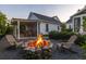 Backyard fire pit with seating area and pergola covered seating area in the evening at 1526 Old Rivers Gate Rd, Mount Pleasant, SC 29466