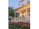 Charming front porch of a white home with a welcoming entrance, complete with lovely landscaping and stylish lighting at 1526 Old Rivers Gate Rd, Mount Pleasant, SC 29466