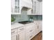 Close up of kitchen showing granite counters, white cabinetry, and an attractive blue tiled backsplash at 1526 Old Rivers Gate Rd, Mount Pleasant, SC 29466