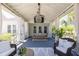 Spacious screened porch features a dining area with chandelier and white curtains at 1526 Old Rivers Gate Rd, Mount Pleasant, SC 29466
