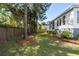 Landscaped backyard features a well-maintained lawn, trees, and a wooden fence for privacy at 1562 Charming Nancy Rd, Charleston, SC 29412