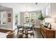 Sunlit dining room with a round glass table, designer light fixture, and large windows offering outdoor views at 1562 Charming Nancy Rd, Charleston, SC 29412