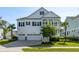 Charming two-story white home boasts a three-car garage, manicured lawn and classic design elements at 1562 Charming Nancy Rd, Charleston, SC 29412