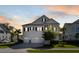Charming two-story white home boasts a three-car garage, manicured lawn and classic design elements at 1562 Charming Nancy Rd, Charleston, SC 29412