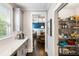 Bright kitchen featuring sleek gray cabinets, quartz countertops, and a walk-in pantry with organized shelving at 1562 Charming Nancy Rd, Charleston, SC 29412
