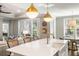 Elegant kitchen island with white countertop, brass fixtures, and views into the living and dining areas at 1562 Charming Nancy Rd, Charleston, SC 29412