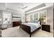 Serene main bedroom with large windows, tray ceilings, and ample natural light, featuring neutral decor and furnishings at 1562 Charming Nancy Rd, Charleston, SC 29412