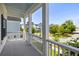 Covered front porch with white columns and railing overlooking the well-maintained yard and the community at 1562 Charming Nancy Rd, Charleston, SC 29412
