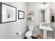 Stylish powder room with pedestal sink, decorative mirror, and charming decorative wall art at 1562 Charming Nancy Rd, Charleston, SC 29412