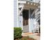 Close up view of front door featuring decorative awning and a rocking chair on the front porch at 1651 Indy Dr, North Charleston, SC 29405