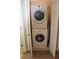 Compact laundry closet featuring a stacked washer and dryer unit with open doors at 1651 Indy Dr, North Charleston, SC 29405