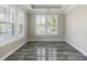 Bright, empty room with neutral walls, wood-look tile floors, and plantation shutters allowing natural light at 1659 Pierce St, Daniel Island, SC 29492