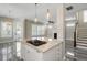 Modern kitchen island with granite countertops and stainless steel gas range overlooks living area and staircase at 1659 Pierce St, Daniel Island, SC 29492