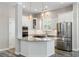 Kitchen island with granite countertop, white cabinets, stainless steel appliances, and wood-look tile floors at 1659 Pierce St, Daniel Island, SC 29492