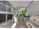 Outdoor kitchen under covered patio featuring a grill, sink, mini refrigerator, and outdoor seating for al fresco dining at 1659 Pierce St, Daniel Island, SC 29492