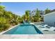 A private pool with in-pool loungers and seating surrounded by lush tropical landscaping at 1659 Pierce St, Daniel Island, SC 29492