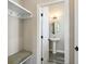 Hallway view of a powder room with a pedestal sink, oval mirror, and neutral walls at 1659 Pierce St, Daniel Island, SC 29492